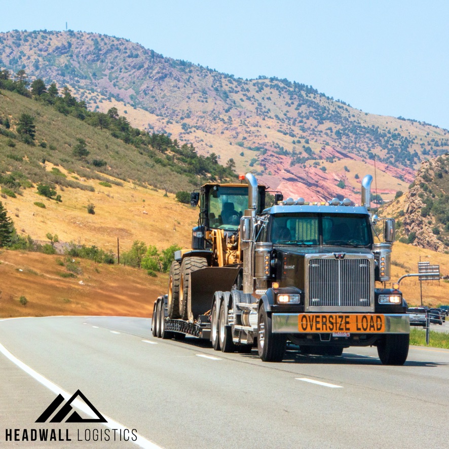 Flatbed photo on the highway hauling heavy haul machinery